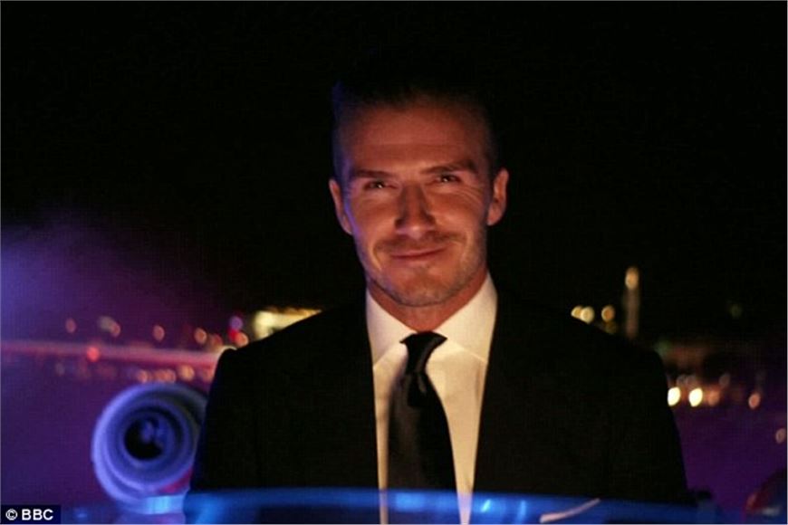 David Beckham ferries the Olympic torch along the Thames via speedboat.