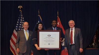 Mayor Dale V.C. Holness and Paola Isaac Baraya Receive President's "E" Award for Export Service from Secretary of Commerce Wilbur Rosson.