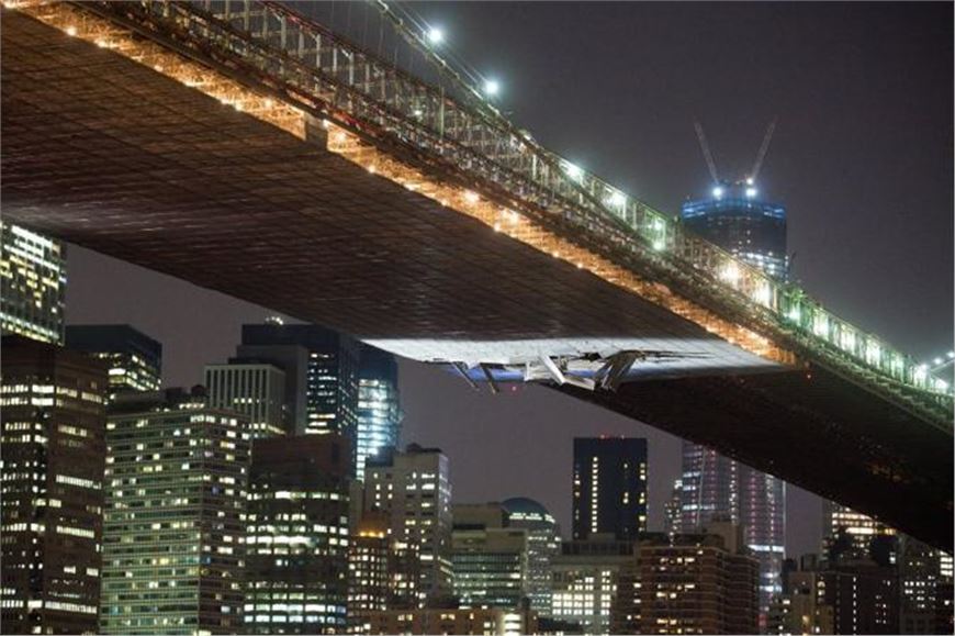 New York. Il ponte di Brooklyn squarciato dal passaggio di una gru 